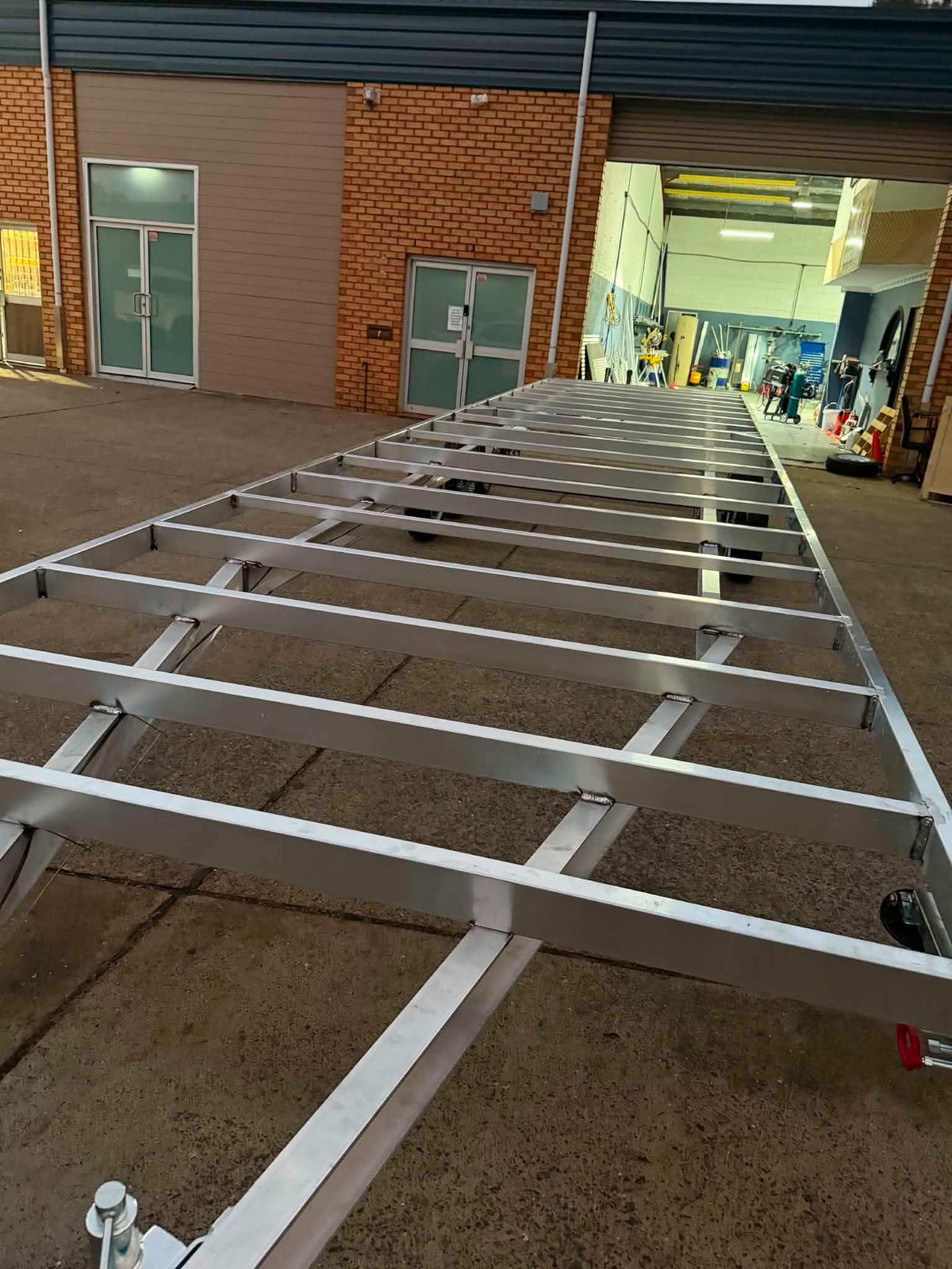 Aluminum Tiny House Trailer 6 meters by 2.4 meter duel Axel aluminum frame in workshop.