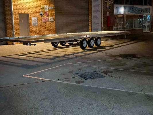 Aluminum Tiny House Trailer 6 meters by 2.4 meter duel Axel aluminum parked at night.