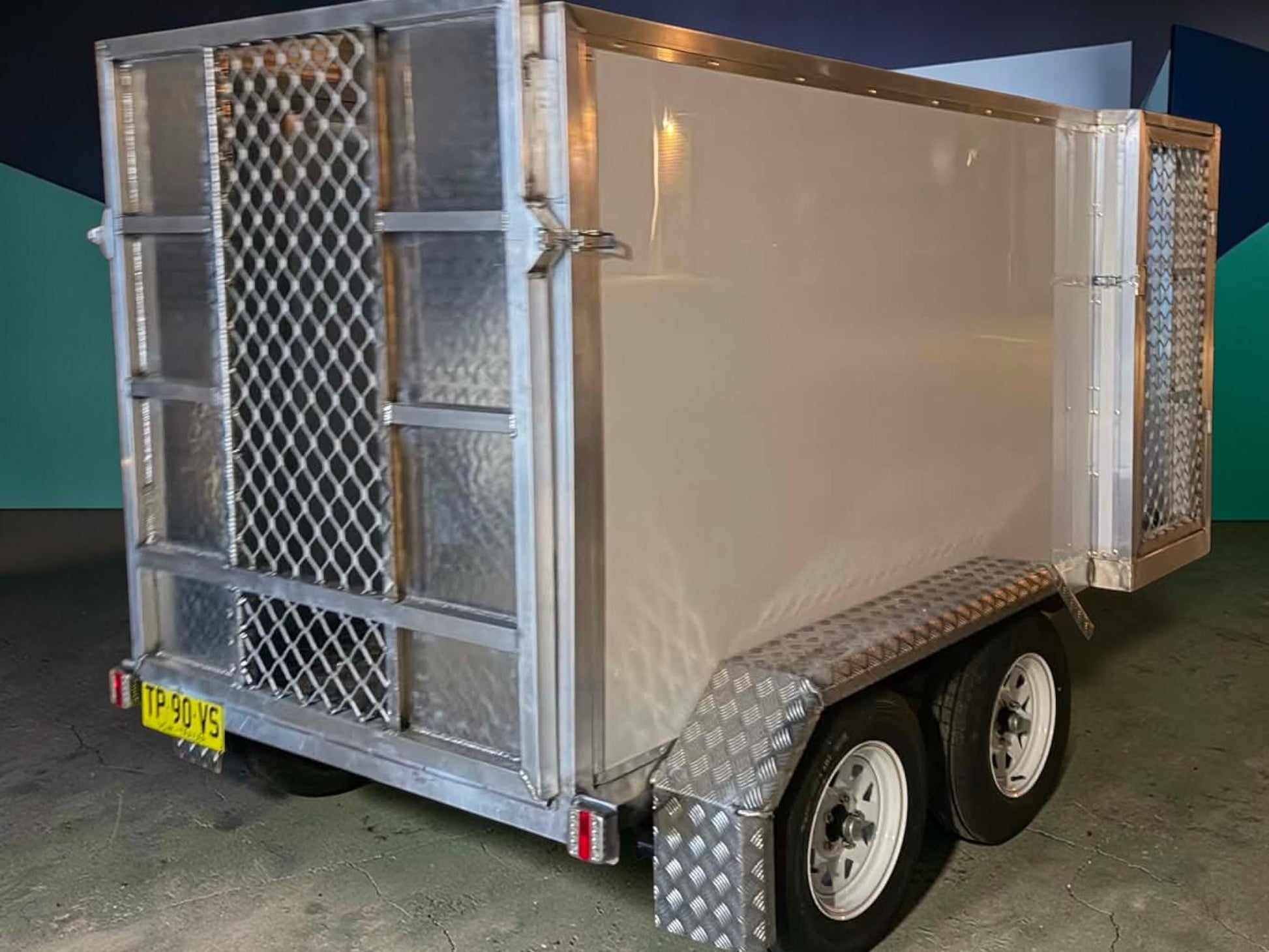 custom aluminum mower trailers with diamond plate fenders and mesh side doors, perfect for landscaping professionals.